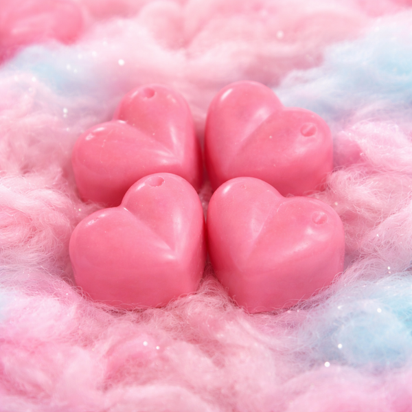 Pink heart-shaped wax melts on a fluffy pink and white background